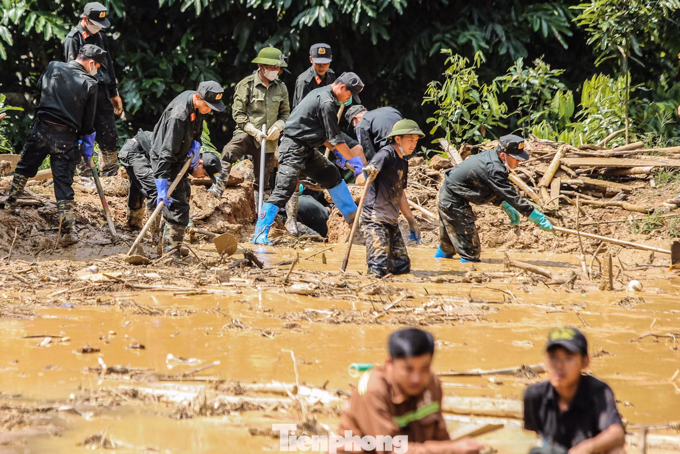 Bên dưới khu vực sạt lở, gần 100 cán bộ, chiến sĩ Tiểu đoàn Cảnh sát Cơ động số 2, Trung đoàn CSCĐ Thủ đô (Bộ Công an) đang lội giữa lớp bùn dày, nỗ lực tìm kiếm người người mất tích.