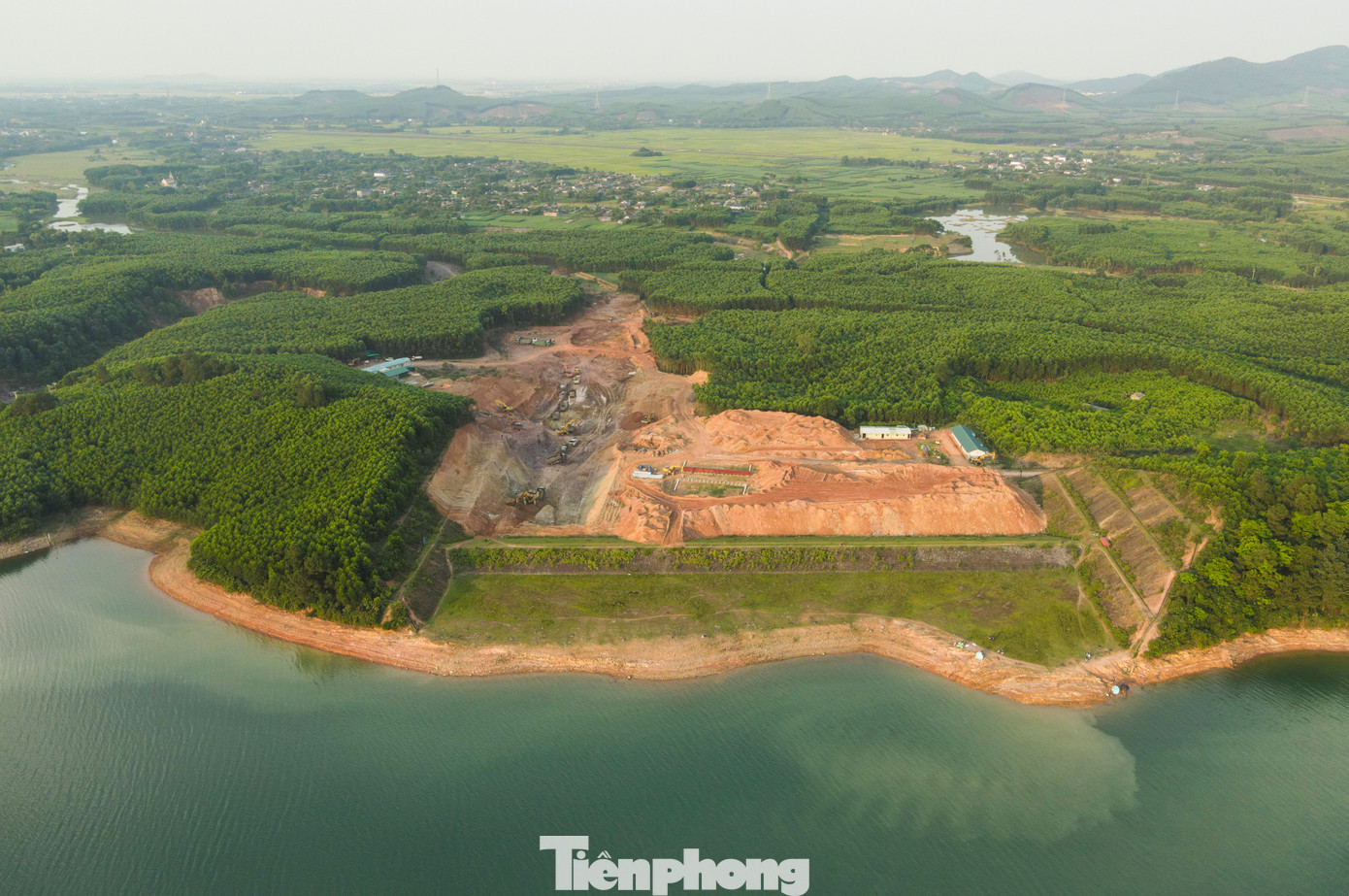 Tại hạng mục xây dựng mới tràn xả lũ - hạng mục dự án nâng cấp, sửa chữa hồ Kẻ Gỗ, máy xúc, máy ủi, xe tải tấp nập làm việc.