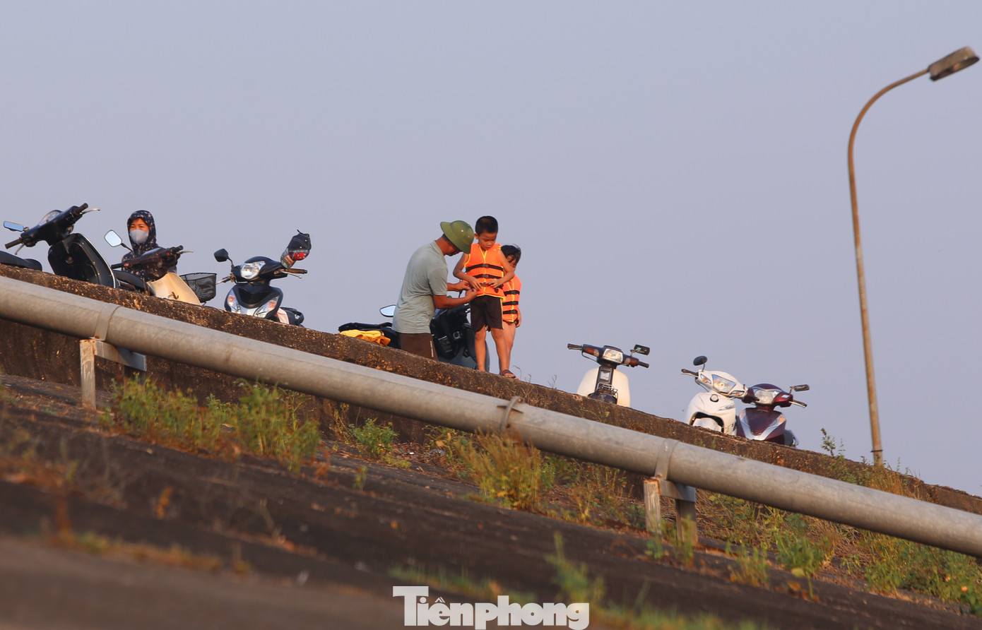 Trước khi tắm, các cháu nhỏ được người lớn mang áo phao.