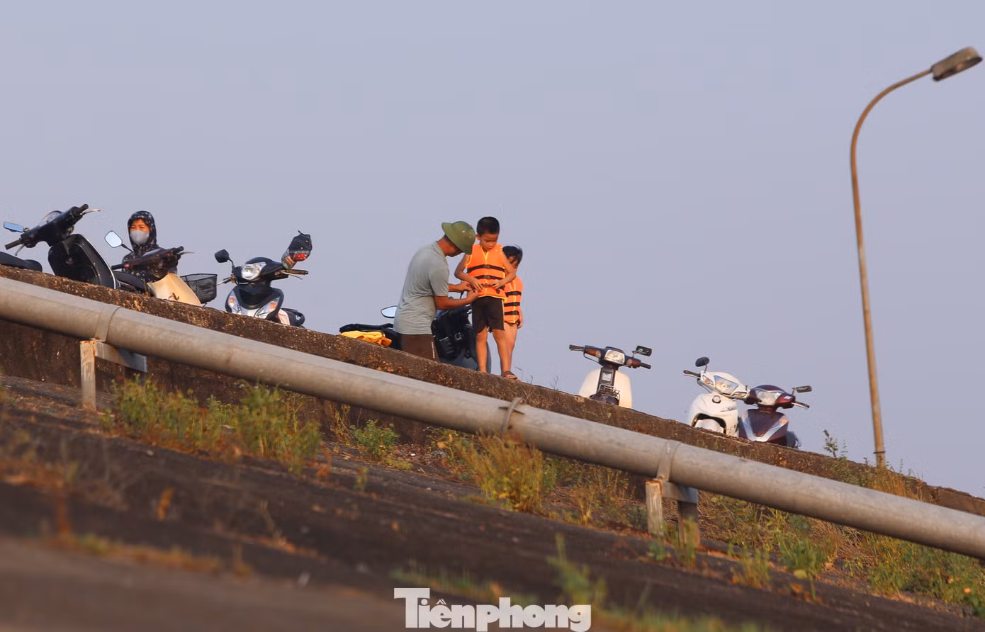 Trước khi tắm, các cháu nhỏ được người lớn mang áo phao.