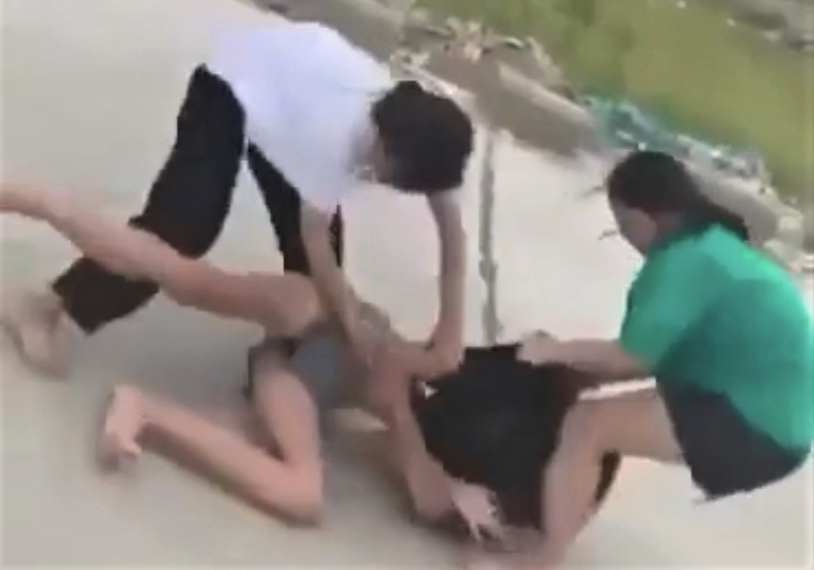 Hình ảnh nữ sinh bị đánh hội đồng trên bờ đê.