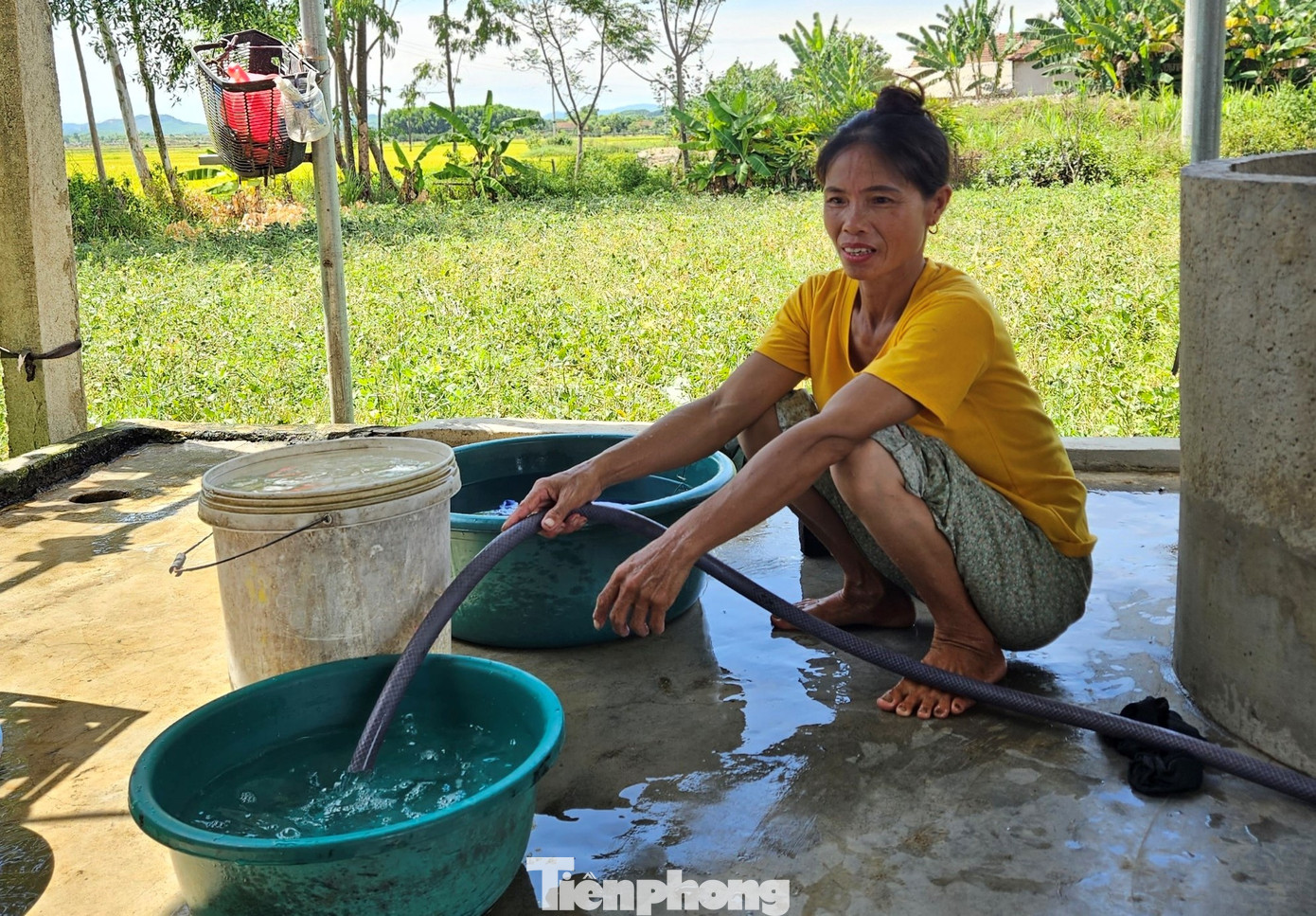 Bà Phạm Thị Xuân bơm nước giếng nhiễm phèn để phục vụ sinh hoạt.