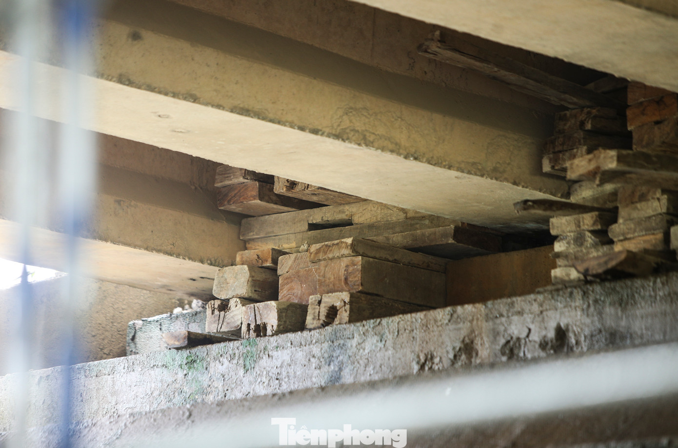 Phía dưới mố cầu bị hư hỏng, các công nhân đang bổ sung thêm dầm ngang giữa các nhịp cầu và sửa chữa đầu dầm bị vỡ bê tông.