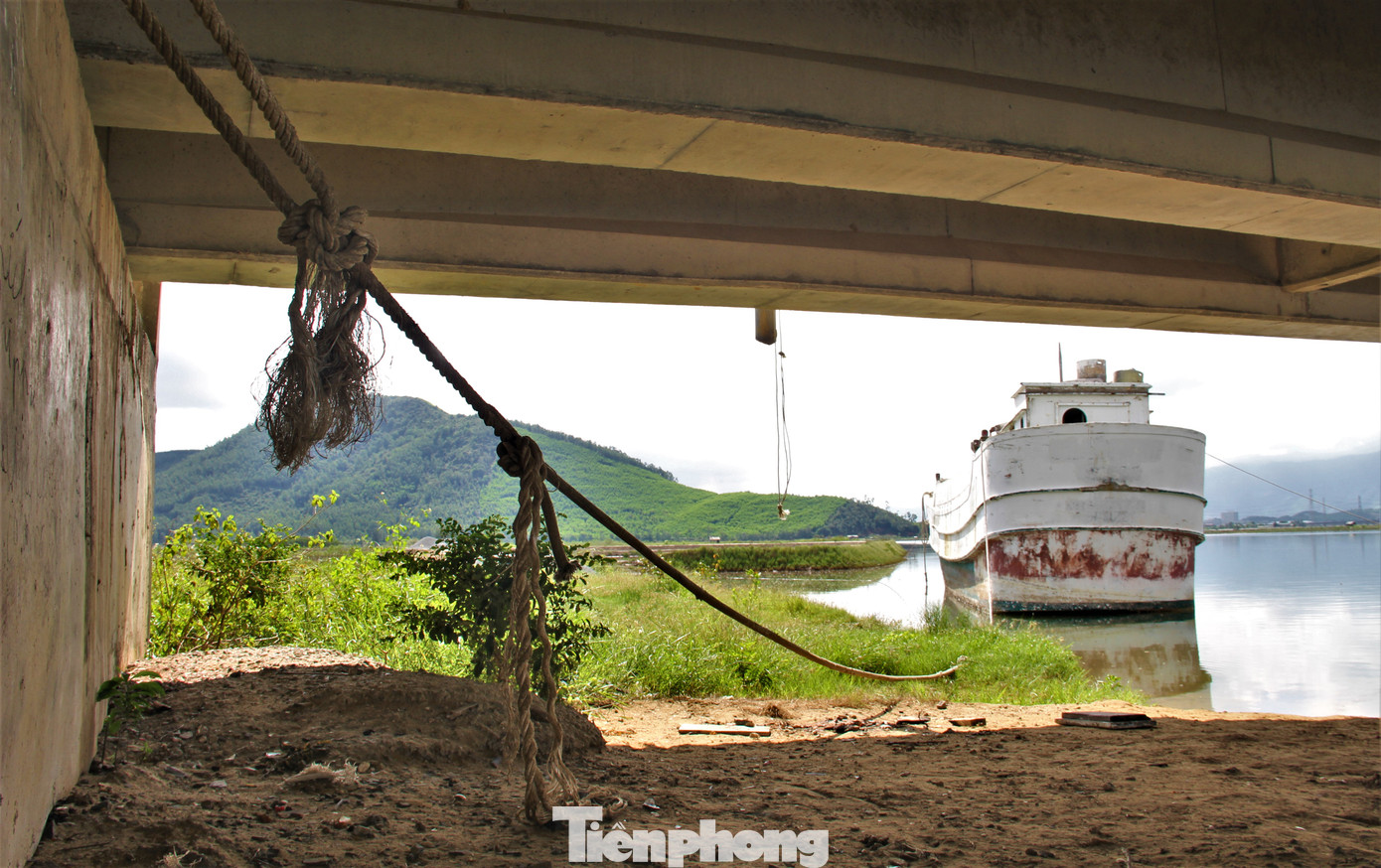 "Tàu không có người trông coi, không rõ chủ nhân là ai. Khu vực này là nơi tàu thuyền của ngư dân vào tránh trú mưa bão nhưng việc xuất hiện của các tàu mắc cạn gây ảnh hưởng cho việc di chuyển", một ngư dân địa phương cho hay. Trong ảnh: Tàu cá được buộc vào chân cầu bằng dây thừng dài hàng chục mét.