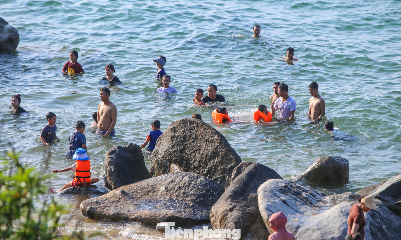 “Các bãi đá ở đây rất tự nhiên và đẹp nên rất phù hợp cho người thích trải nghiệm, thích cảm giác khám phá”, chị Hồng Vân (du khách từ Bắc Ninh) cho hay. Trong hình, du khách tắm thành từng tốp 10-20 người, ở các dải cát vàng xen các bãi đá.