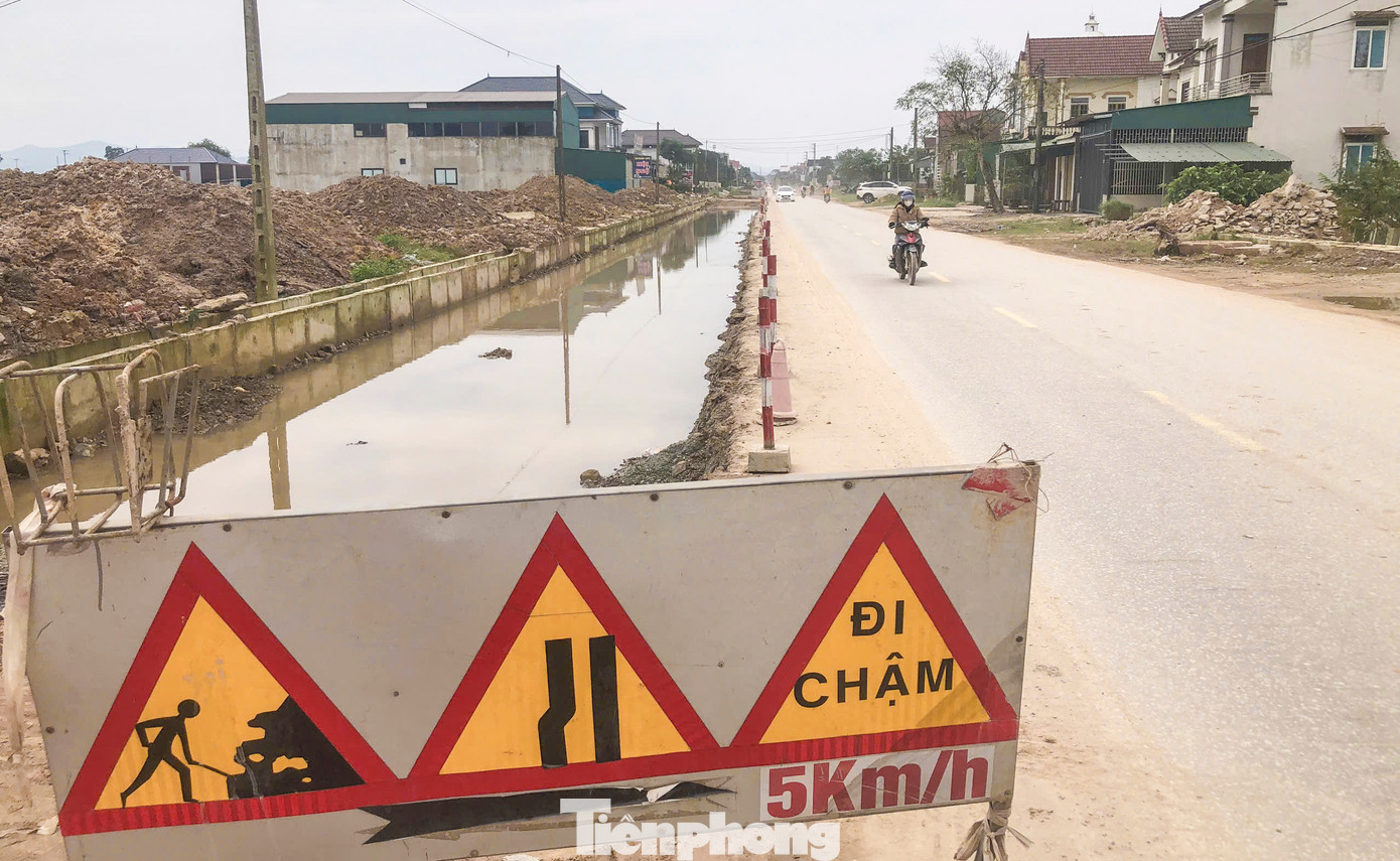 Mặt bằng còn vướng khiến nhà thầu phải thi công nhảy cóc. Nhiều vị trí thiếu đất đắp, mương rãnh thoát nước nằm ngổn ngang, nước lênh láng.