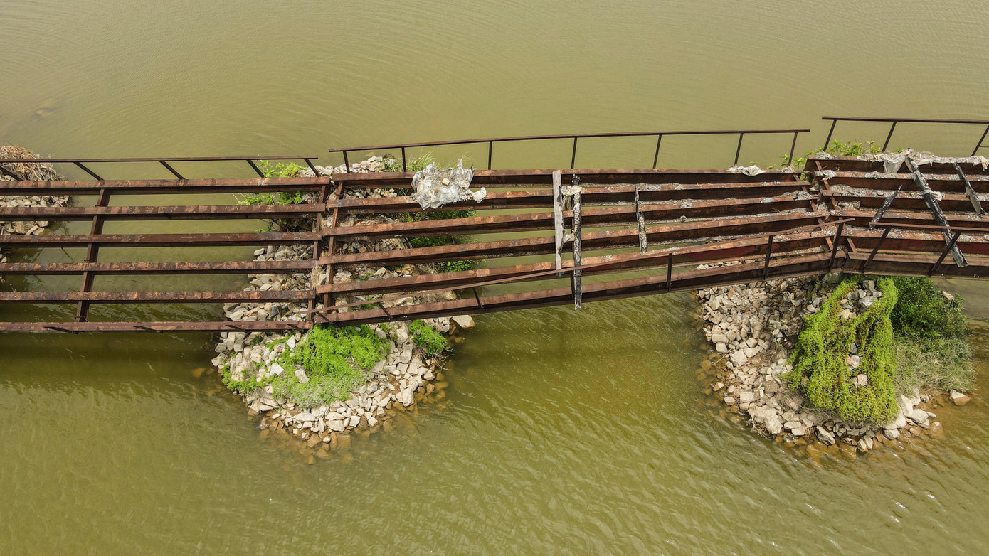 Theo ghi nhận, các hạng mục của cầu hư hỏng, hoen gỉ, xuống cấp, đổ nghiêng. Phía hai đầu cầu không có rào chắn hay biển cảnh báo nguy hiểm, xung quanh cây cỏ dại mọc um tùm nhếch nhác. “Cầu đã xuống cấp, không thể đi lại nữa nên nếu sửa chữa được nên làm sớm hoặc tháo dỡ, tránh để mùa lũ nước lớn có cầu chắn rất nguy hiểm”, ông Tiếp (68 tuổi) cho hay.