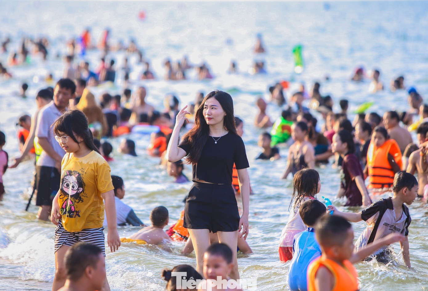 Bãi biển phủ kín người nên nhiều bạn trẻ không chen chúc tắm mát mà đứng cạnh bãi tắm.