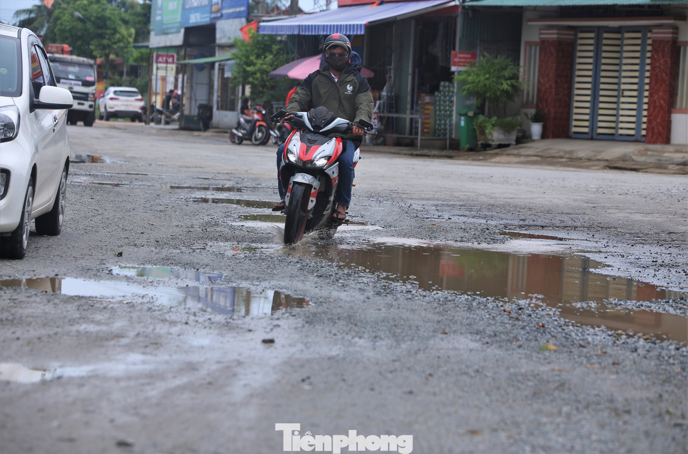 "Nhiều vị trí bị bong tróc thành từng vũng sâu, ngày nắng thì bụi bặm, ngày mưa nước ngập nên phương tiện qua lại gặp khó khăn, nguy hiểm. Ngành chức năng đôi lần rải đá bây trám các ổ voi nhưng đó chỉ là biện pháp tạm thời, cần có dự án nâng cấp để cứu con đường này", anh Chiến (xã Khánh Vĩnh Yên), chia sẻ. Trong ảnh là cảnh người và phương tiện giao thông gặp khó khi qua vị trí hư hỏng ở xã Khánh Vĩnh Yên, huyện Can Lộc.
