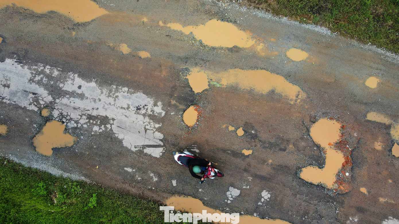 Mưa lớn khiến nước đọng các hố sụt lún, gây khó khăn cho người đi lại.