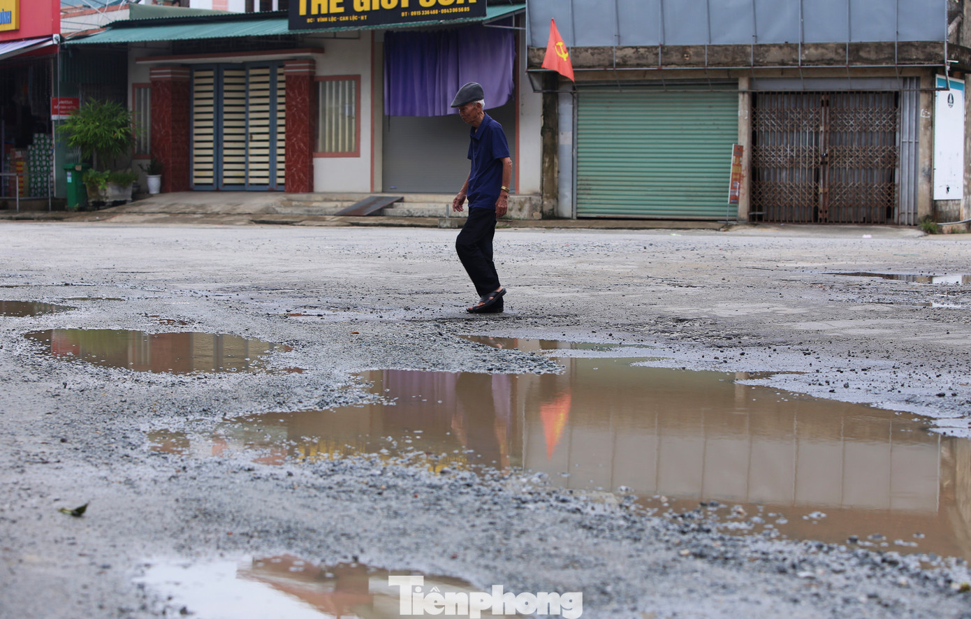"Nhiều vị trí bị bong tróc thành từng vũng sâu, ngày nắng thì bụi bặm, ngày mưa nước ngập nên phương tiện qua lại gặp khó khăn, nguy hiểm. Ngành chức năng đôi lần rải đá bây trám các ổ voi nhưng đó chỉ là biện pháp tạm thời, cần có dự án nâng cấp để cứu con đường này", anh Chiến (xã Khánh Vĩnh Yên), chia sẻ. Trong ảnh là cảnh người và phương tiện giao thông gặp khó khi qua vị trí hư hỏng ở xã Khánh Vĩnh Yên, huyện Can Lộc.