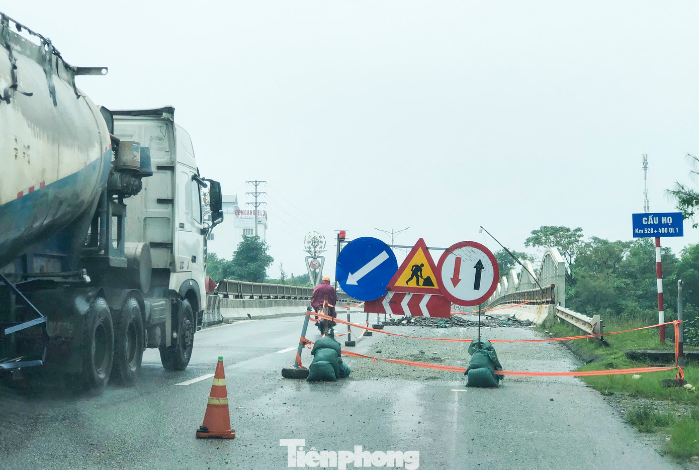 “Mưa lớn kéo dài cùng lưu lượng phương tiện lớn nên việc xuống cấp, hư hỏng khó tránh khỏi. Việc sửa chữa cũng chỉ là cục bộ để đảm bảo an toàn cho người và phương tiện qua lại vì kinh phí trùng tu hàng năm có hạn, rất khó khăn”, ông Giang chia sẻ. Trong hình là một vị trí sửa chữa mặt cầu Họ (huyện Cẩm Xuyên). Đơn vị thi công đã ngăn một nửa làn đường song mưa nhiều ngày khiến việc thi công tạm dừng.