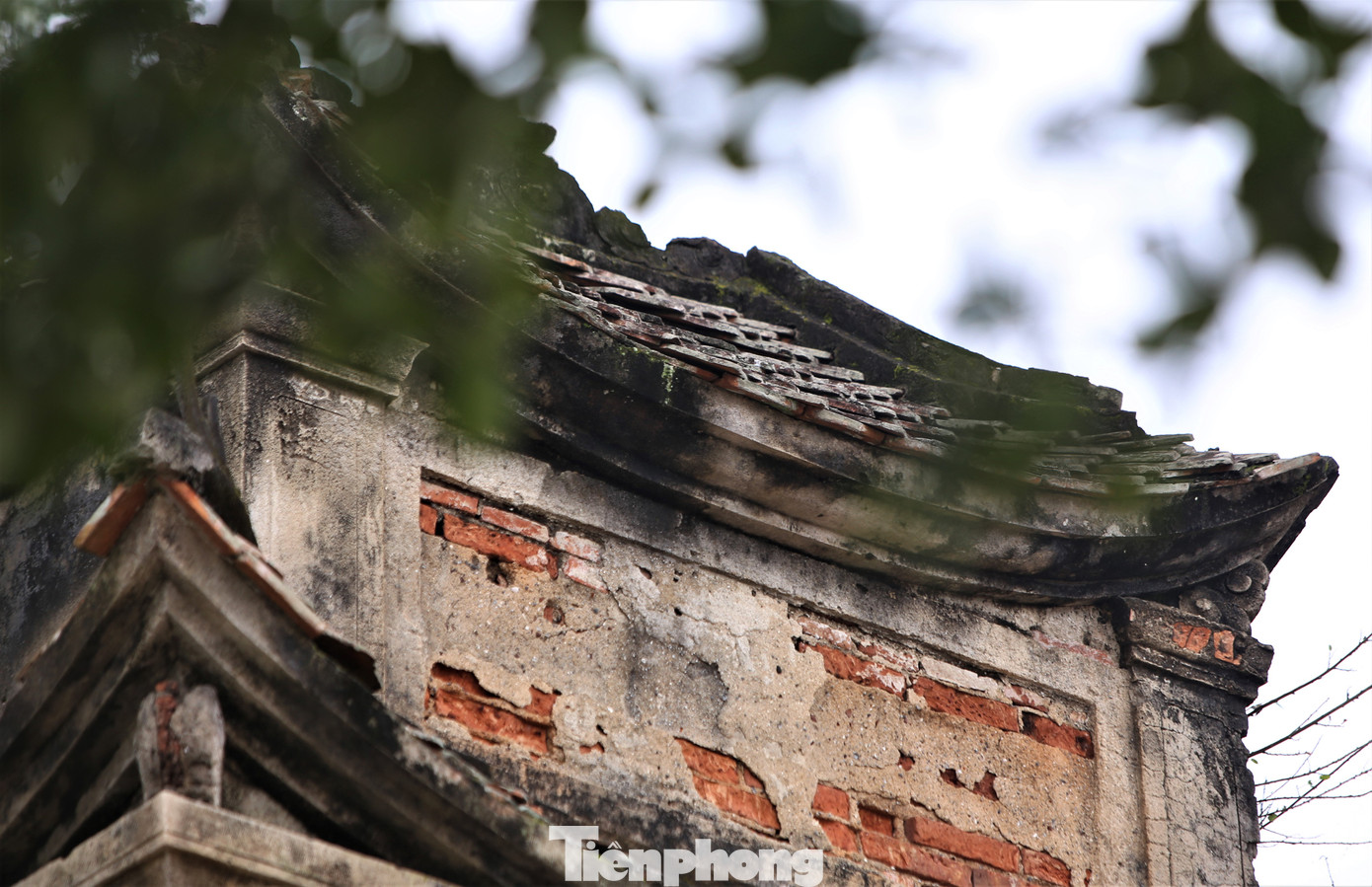 Trên đỉnh có có mái ngói, hoa văn, chữ viết. Qua thời gian, biến cố lịch sử, nhiều mảng vữa rơi ra, một số cây bám vào cổng đền. Trước khi di dời, đơn vị thi công đã chằng buộc các cọc, thanh đỡ sắt. Trên đỉnh có có mái ngói, hoa văn, chữ viết. Qua thời gian, biến cố lịch sử, nhiều mảng vữa rơi ra, một số cây bám vào cổng đền. Trước khi di dời, đơn vị thi công đã chằng buộc các cọc, thanh đỡ sắt.