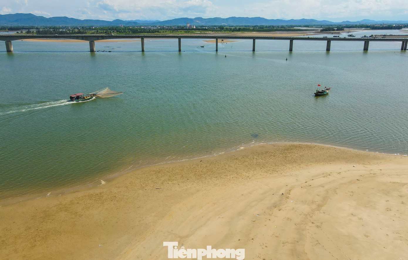 “Luồng lạch chưa hút được nhiều khiến nhiều tàu 12-15m khó ra, vào nên phải dừng ngoài luồng, bo hải sản bằng thuyền thúng vào rất khó khăn”, ngư dân Nguyễn Tiến Huy (trú xã Cẩm Nhượng, huyện Cẩm Xuyên) cho hay. Trong ảnh, hình ảnh những cồn cát “bủa vây” lối ra, vào cảng cá, gây khó cho tàu thuyền.
