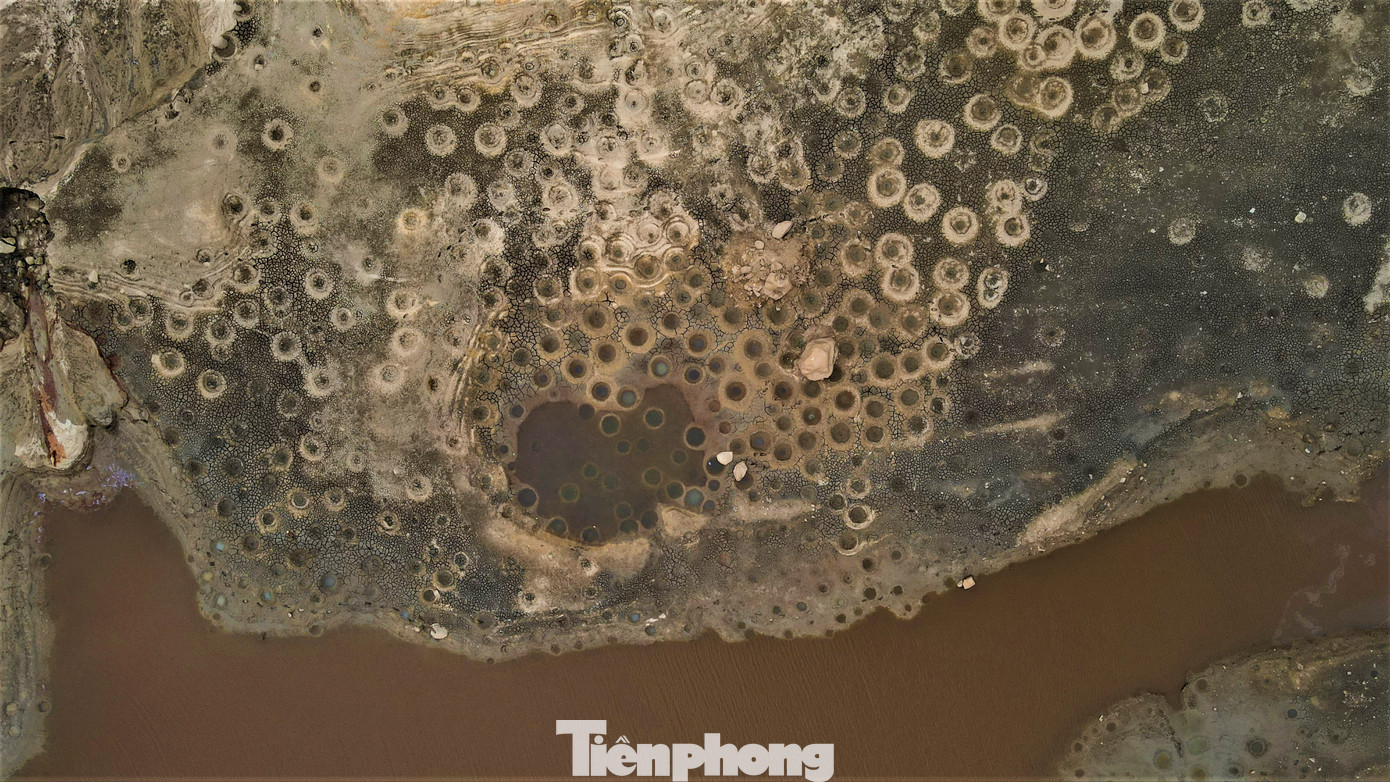 Nhìn từ trên cao, lòng hồ xuất hiện những vũng bùn như hố bom. Người dân cho biết đó là những vũng bùn do đàn cá làm tổ hình thành nên.