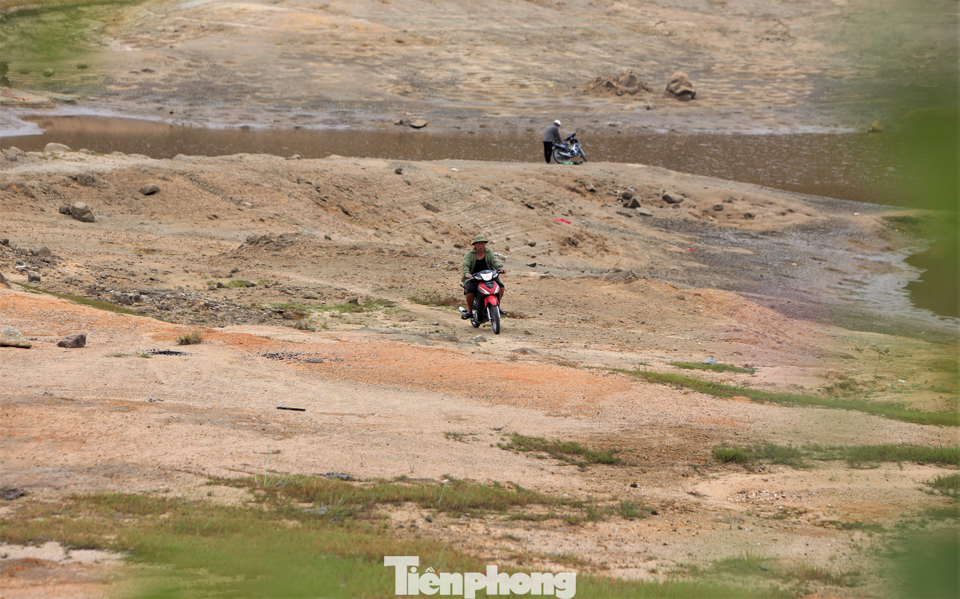 Người dân chạy xe máy trên lòng hồ cạn khô.