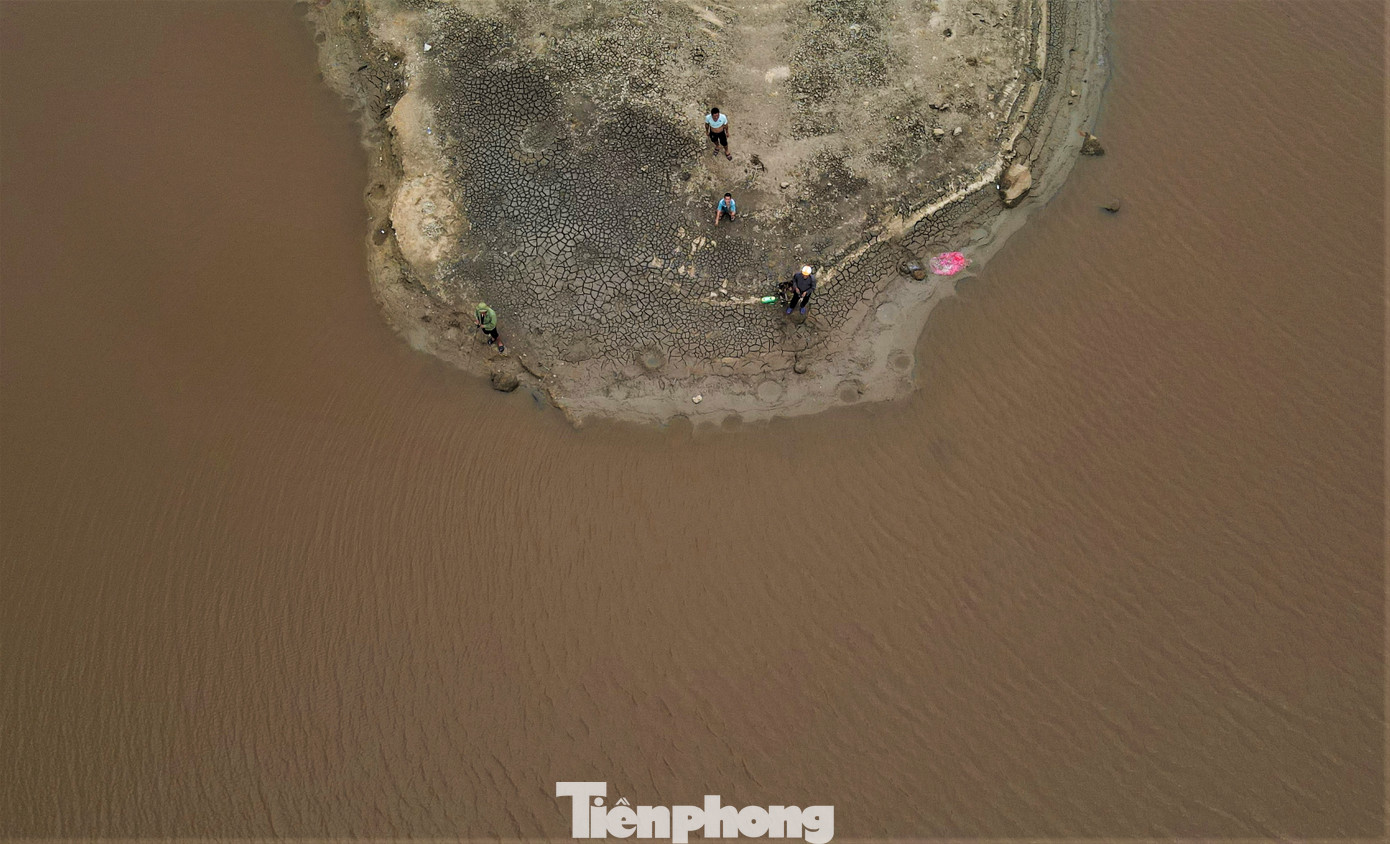 Mực nước hồ xuống thấp, nhiều người dân tranh thủ đến câu cá hoặc dạo bộ trên lòng hồ.