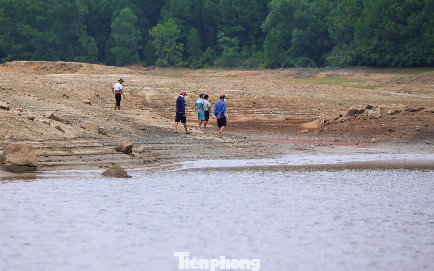 Mực nước hồ xuống thấp, nhiều người dân tranh thủ đến câu cá hoặc dạo bộ trên lòng hồ.
