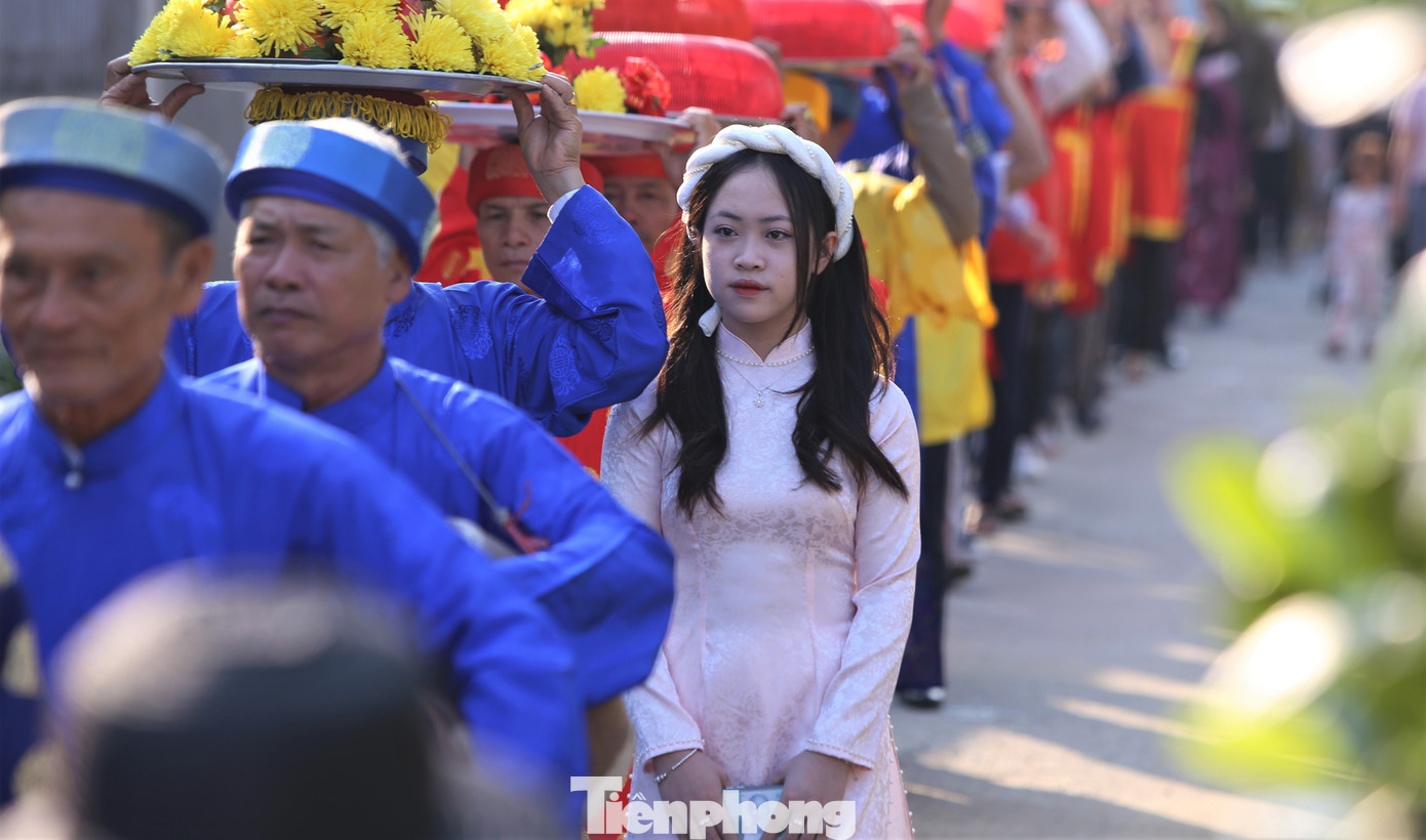 Các thiếu nữ diện áo dài xinh xắn hòa vào dòng người bưng mâm lễ.