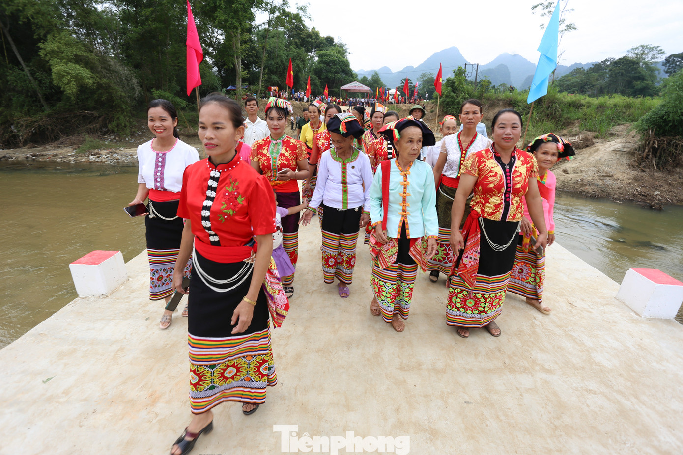 Người dân địa phương phấn khởi, vui mừng rảo bước trên cây cầu mới xây xong.