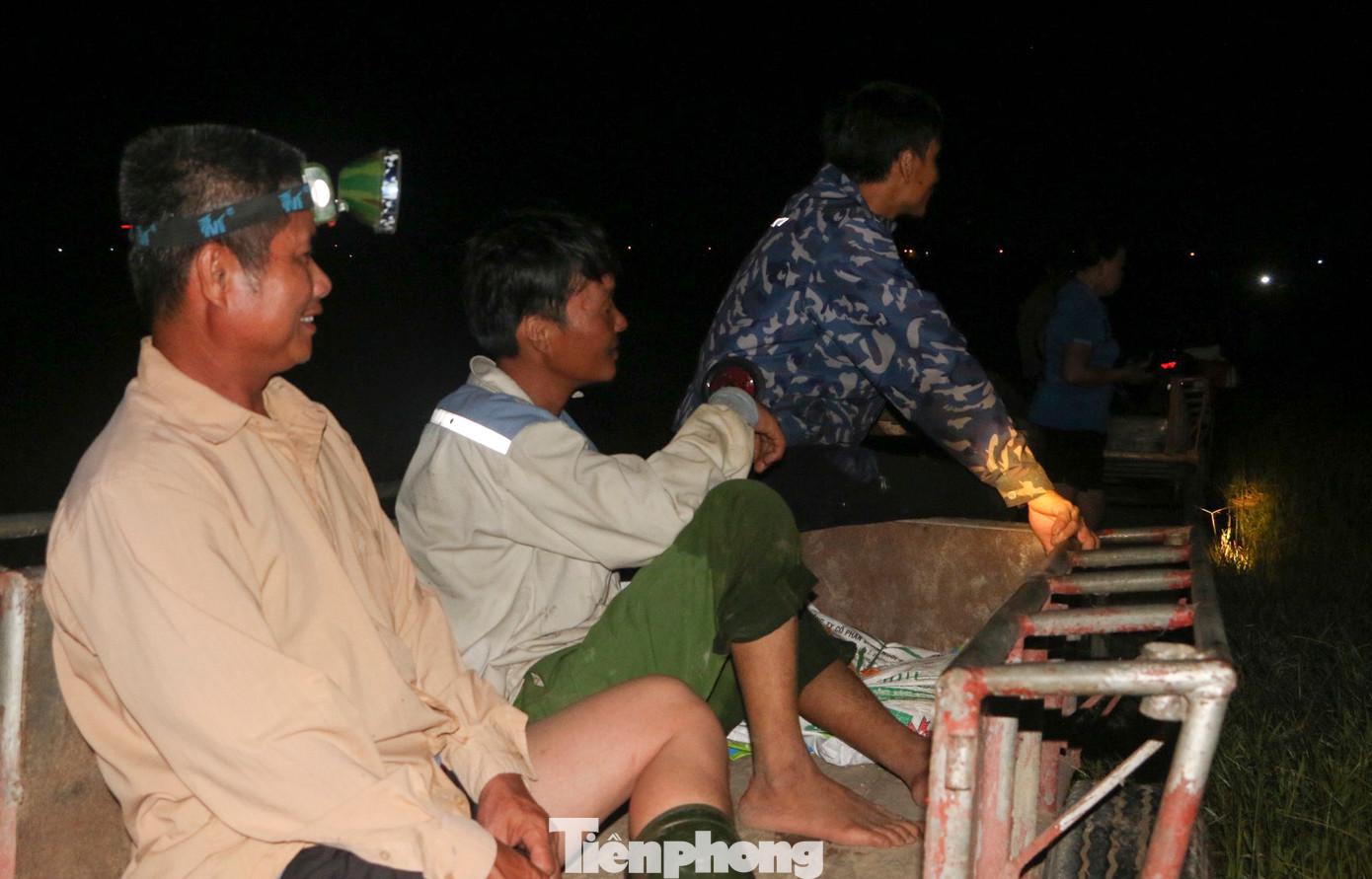 Các hộ dân đứng ven đường nội đồng, trên đầu đội đèn pin chờ tới lượt thu hoạch lúa. Niềm vui khi có vụ mùa năng suất.