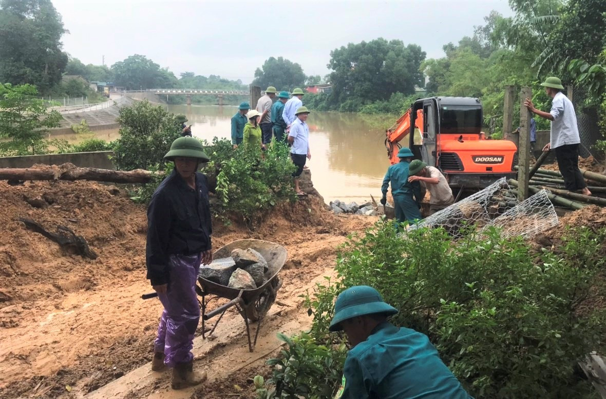 Dù trời mưa song cả trăm người vẫn cố gắng khắc phục sự cố sạt lở bờ sông.