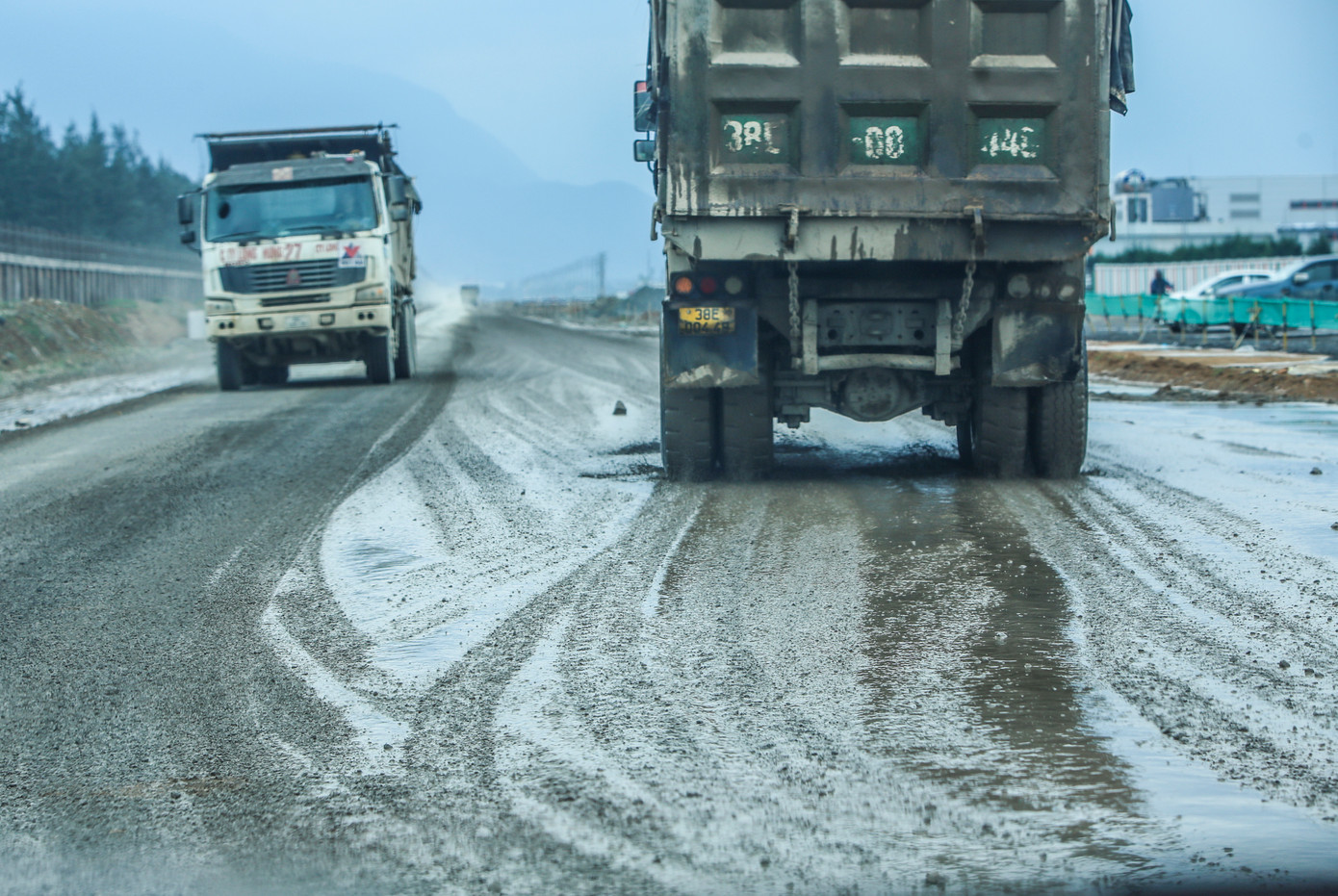 “Xe nhiều mà tài xế chạy nhanh nên vật liệu rơi vãi, vừa bụi, vừa nguy hiểm cho người dân tham gia giao thông. Nhiều đoạn đường cũng bị bong tróc, xuống cấp khi lượng xe chạy liên tục”, anh Thắng (34 tuổi) cho hay. Trong ảnh, xe chạy liên tục khiến mặt đường lầy lội, bùn nhão gây khó cho người tham gia giao thông.