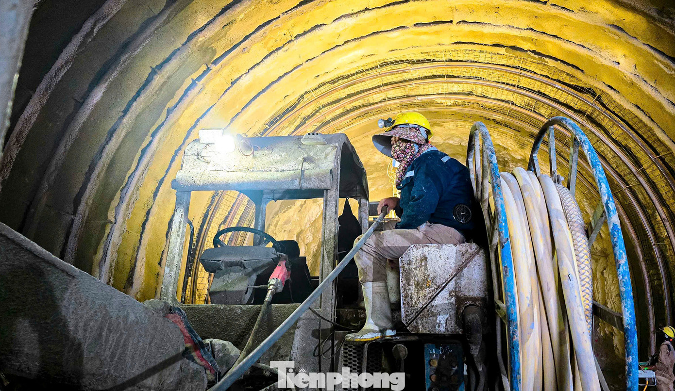 “Làm việc trong hầm không ảnh hưởng nhiều bởi thời tiết song khói bụi và môi trường bí bách hơn nên anh em phải mặc bảo hộ dày, đội mũ, đeo khẩu trang làm việc liên tục”, anh Cường (quê Thanh Hóa) chia sẻ. Trong hình công nhân, kỹ sư cùng nhiều thiết bị, máy móc, robot đào hầm hiện đại làm việc xuyên suốt ngày đêm.