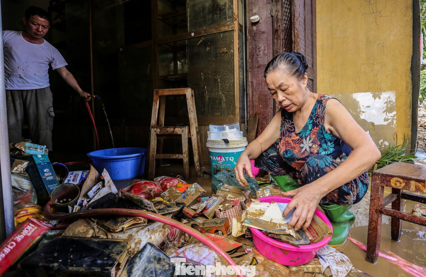 “Bao năm sống ở đây, chưa bao giờ có đợt lũ lên nhanh, gây ngập sâu như vậy. Vợ chồng tôi chỉ kịp chạy lên tầng trên tránh nạn, tất cả tài sản, đồ đạc bị ngâm trong nước. Giờ thì trắng tay...”, bà Tâm nói. Trong hình, vợ chồng bà Tâm cố nhặt nhạnh những gì còn sót lại sau trận lũ dữ.