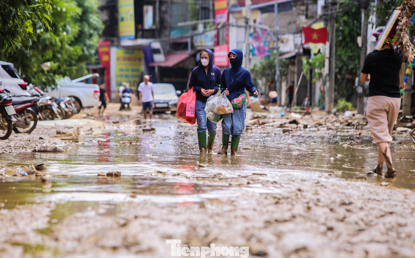 Lũ rút, trong nhà dân và các tuyến đường để lại lớp bùn dày đặc, cao đến đầu gối khiến người và phương tiện gặp khó khăn trong đi lại.