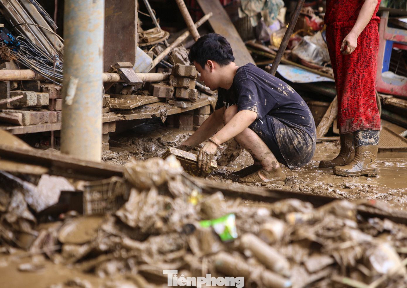 Người dân TP Yên Bái dọn bùn đất sau lũ, tìm kiếm những gì còn dùng được. Đến nay, một số khu vực chưa có điện nên việc gạt bùn gặp khó khăn.