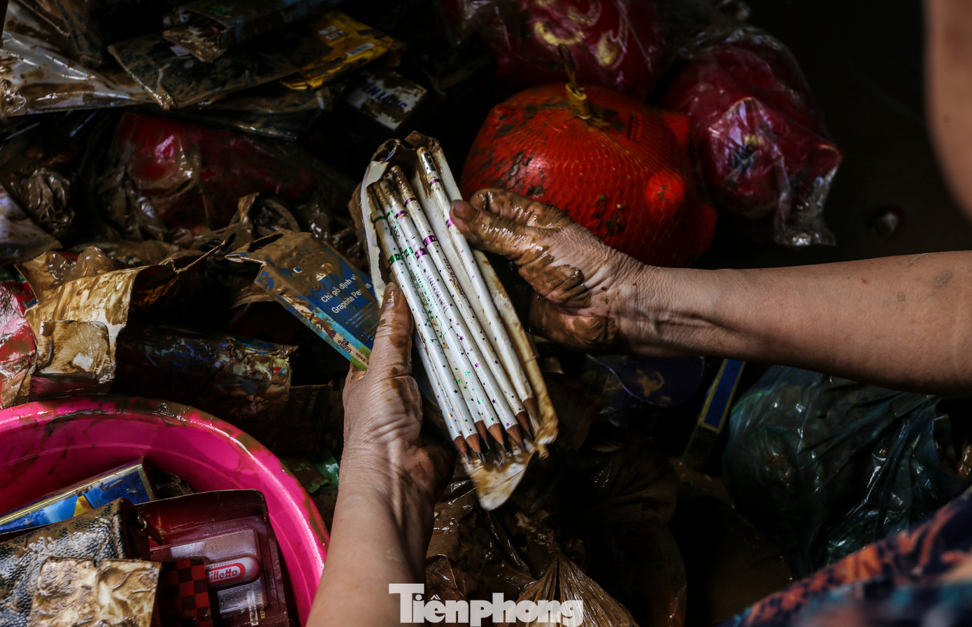 “Bao năm sống ở đây, chưa bao giờ có đợt lũ lên nhanh, gây ngập sâu như vậy. Vợ chồng tôi chỉ kịp chạy lên tầng trên tránh nạn, tất cả tài sản, đồ đạc bị ngâm trong nước. Giờ thì trắng tay...”, bà Tâm nói. Trong hình, vợ chồng bà Tâm cố nhặt nhạnh những gì còn sót lại sau trận lũ dữ.