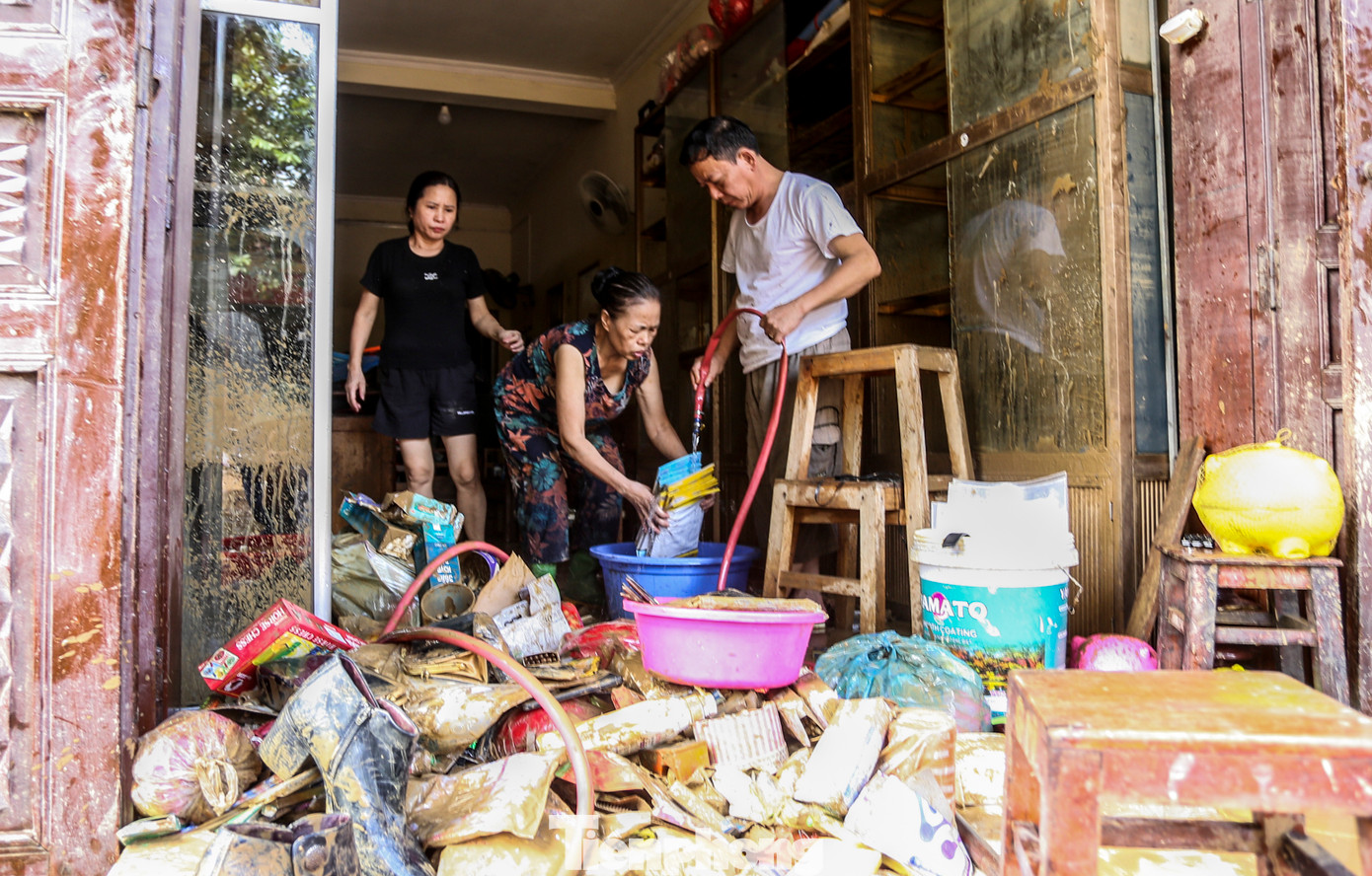 “Bao năm sống ở đây, chưa bao giờ có đợt lũ lên nhanh, gây ngập sâu như vậy. Vợ chồng tôi chỉ kịp chạy lên tầng trên tránh nạn, tất cả tài sản, đồ đạc bị ngâm trong nước. Giờ thì trắng tay...”, bà Tâm nói. Trong hình, vợ chồng bà Tâm cố nhặt nhạnh những gì còn sót lại sau trận lũ dữ.