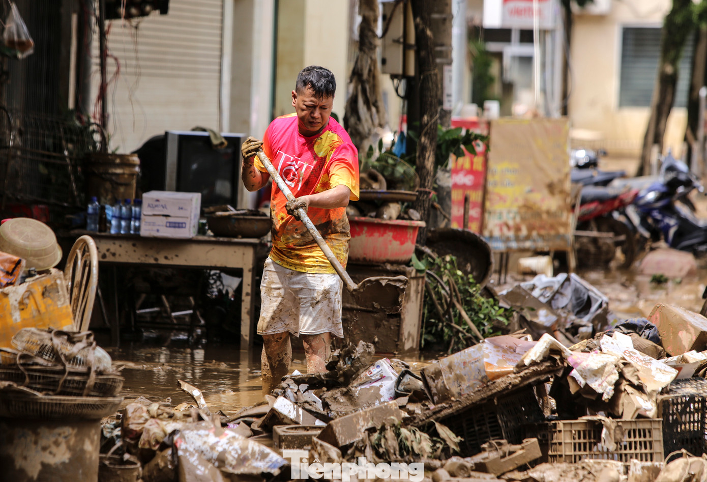 Người dân TP Yên Bái dọn bùn đất sau lũ, tìm kiếm những gì còn dùng được. Đến nay, một số khu vực chưa có điện nên việc gạt bùn gặp khó khăn.
