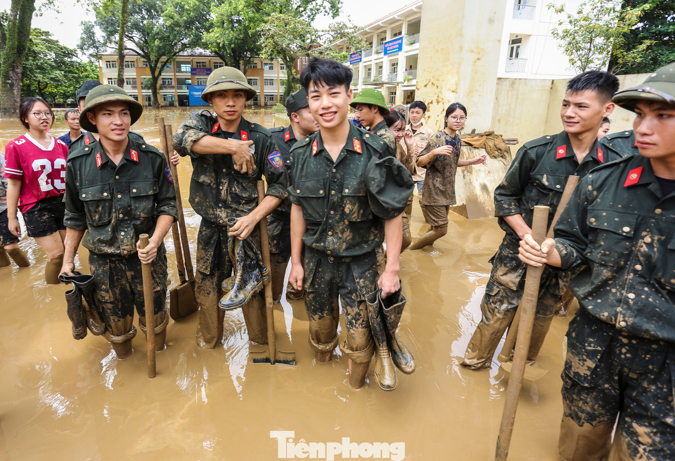 Các chiến sĩ cảnh sát cơ động lấm lem bùn sau khi hỗ trợ dọn dẹp trường học.