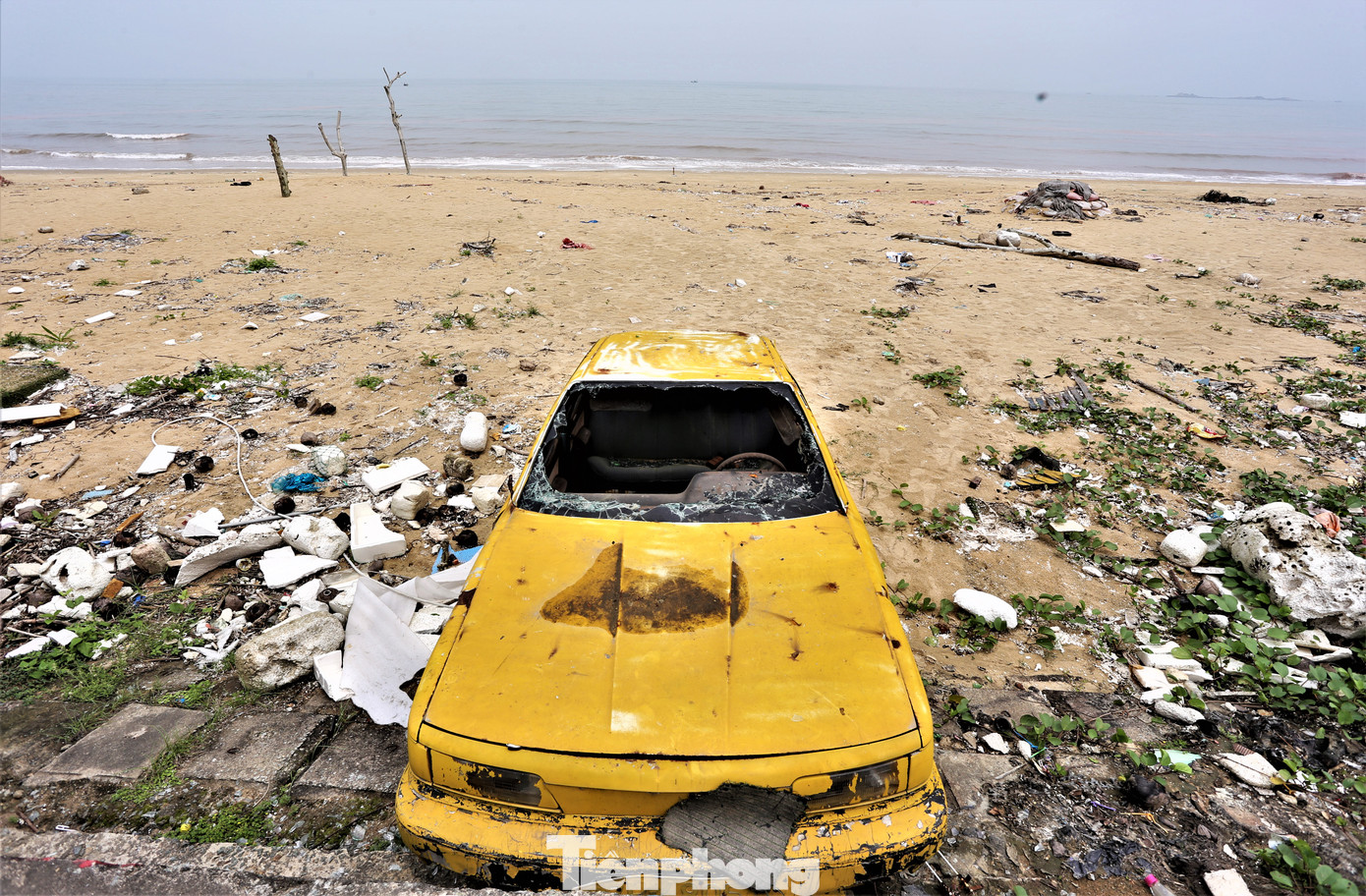 Chiếc ô tô cũ trưng bày trên bãi biển hoen gỉ, nhếch nhác.