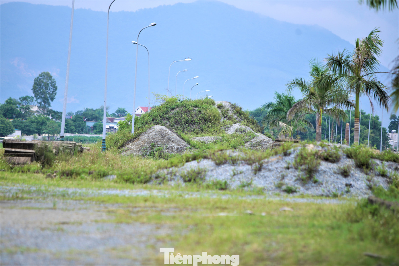 Cấu kiện cùng vật liệu xây dựng nằm ngổn ngang trong khuôn viên dự án, cỏ cây mọc kín.