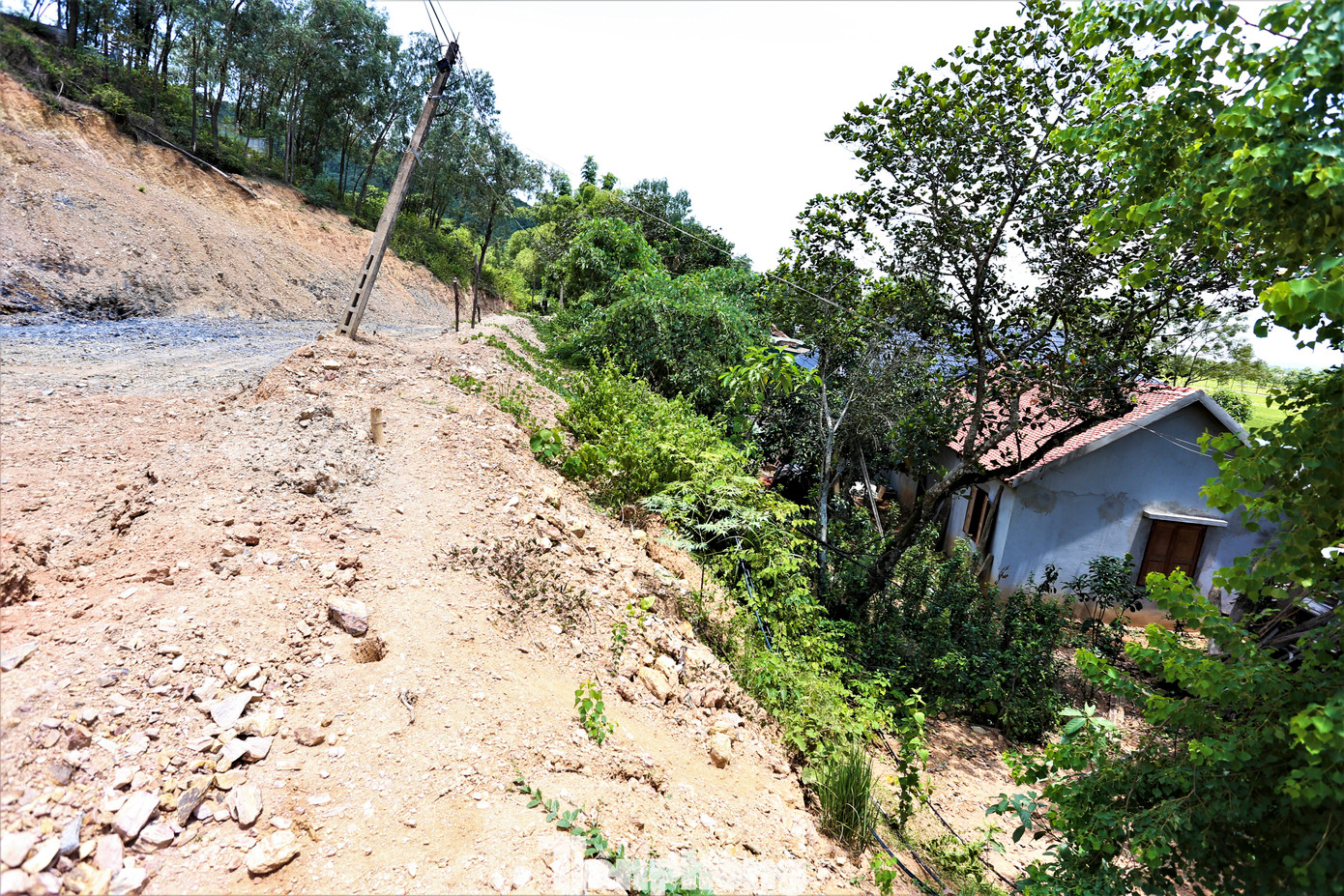 Nhà các hộ dân nằm dưới đường băng rộng hàng chục mét song chưa có rãnh thoát nước khiến người dân bất an.