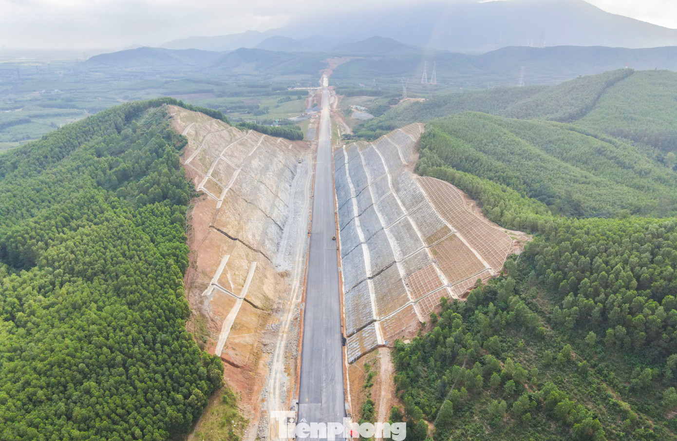 Trong hình là đoạn đường xuyên đồi Ba Vồng (xã Kỳ Tân, huyện Kỳ Anh, Hà Tĩnh) thuộc đoạn cao tốc Vũng Áng – Bùng. Đoạn tuyến này có tổng mức đầu tư hơn 12.500 tỷ đồng, được khởi công từ ngày 1/1/2023 do Ban QLDA 6 (Bộ GTVT) làm chủ đầu tư. Sau thời gian thi công, ngọn đồi đã được hạ 60m, kè sạt lở, đơn vị thực hiện dự án đang hoàn thiện các hạng mục cuối như thảm lớp nhựa cuối và lắp hệ thống lan can, biển báo. Trong hình là đoạn đường xuyên đồi Ba Vồng (xã Kỳ Tân, huyện Kỳ Anh, Hà Tĩnh) thuộc đoạn cao tốc Vũng Áng – Bùng. Đoạn tuyến này có tổng mức đầu tư hơn 12.500 tỷ đồng, được khởi công từ ngày 1/1/2023 do Ban QLDA 6 (Bộ GTVT) làm chủ đầu tư. Sau thời gian thi công, ngọn đồi đã được hạ 60m, kè sạt lở, đơn vị thực hiện dự án đang hoàn thiện các hạng mục cuối như thảm lớp nhựa cuối và lắp hệ thống lan can, biển báo.