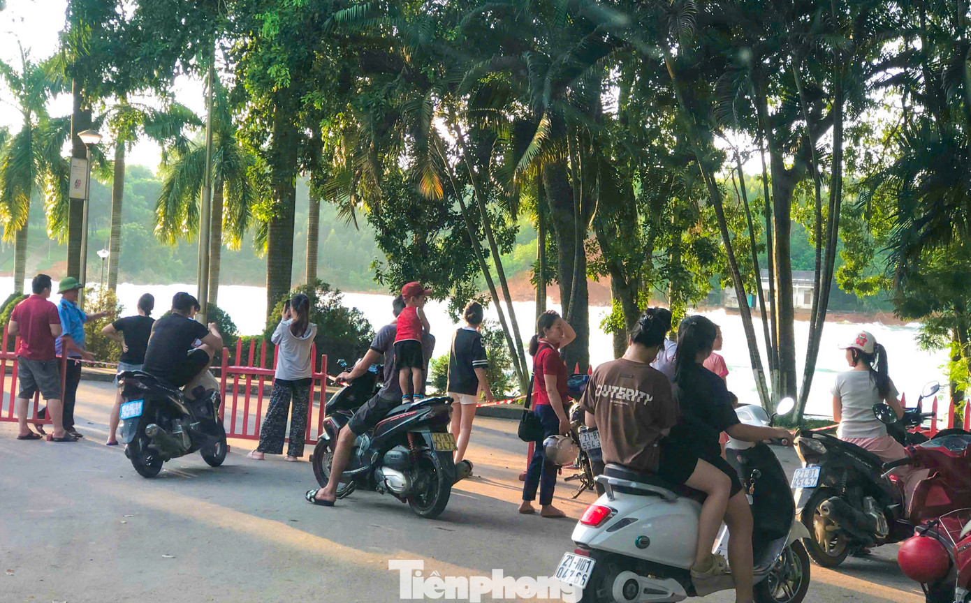 Thấy hồ thủy điện Thác Bà xả lũ, rất đông người dân địa phương và du khách di chuyển lên khu vực cửa xả để xem song bị bảo vệ ngăn lại để đảm bảo an toàn.