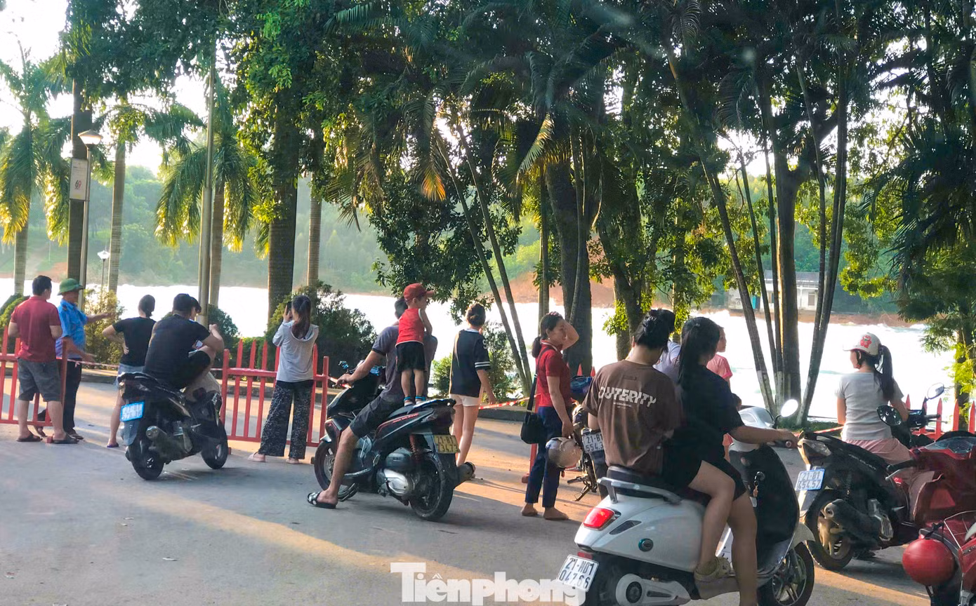 Thấy hồ thủy điện Thác Bà xả lũ, rất đông người dân địa phương và du khách di chuyển lên khu vực cửa xả để xem song bị bảo vệ ngăn lại để đảm bảo an toàn.