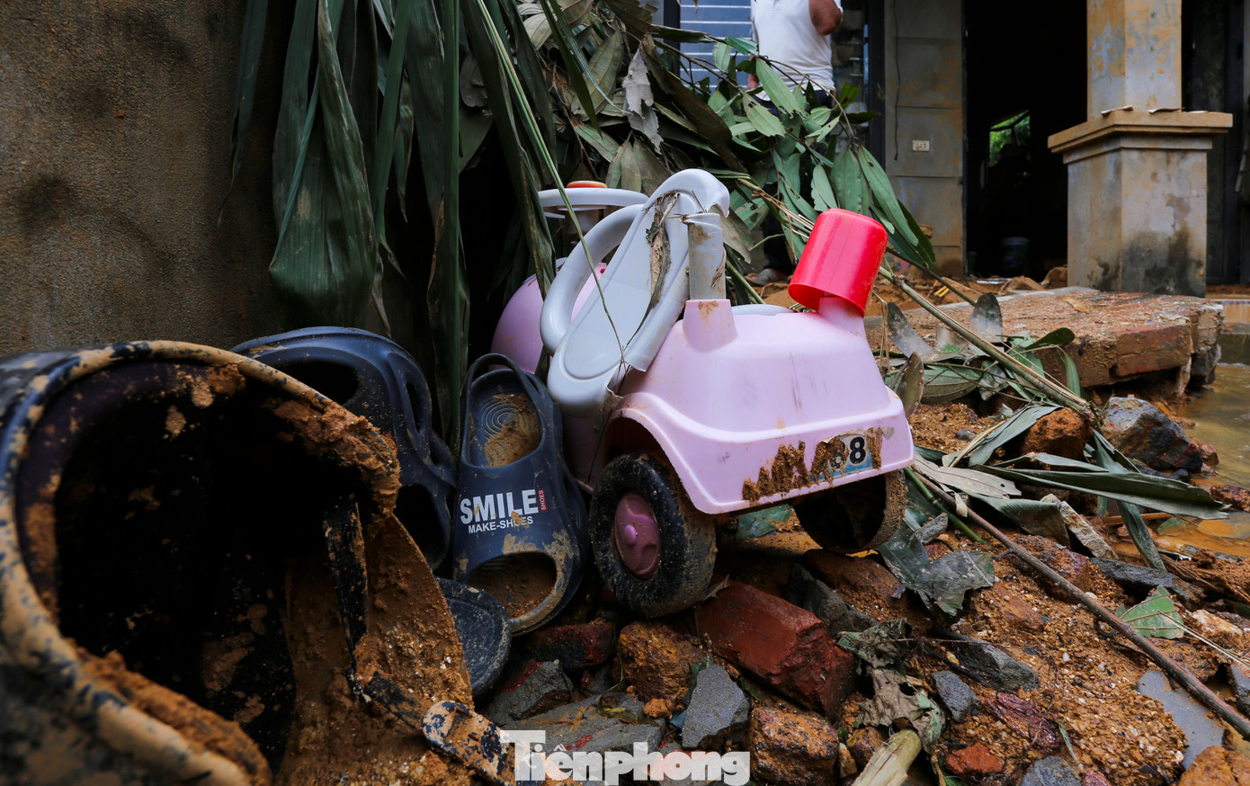 Vụ sạt lở đã vò nát cả mảng tường và các vật dụng bên trong. Trong làn nước mưa, lớp bùn dày chỉ còn những bộ quần áo bị bùn nhuốm màu, chiếc xe đồ chơi của trẻ em.