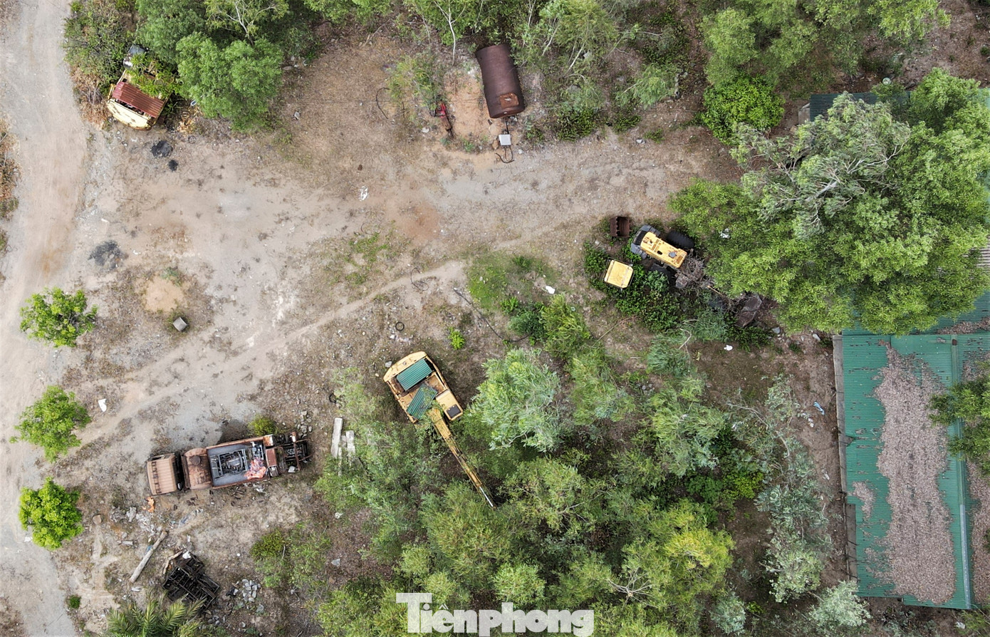 Các loại máy móc, ô tô phục vụ khai thác, vận chuyển khoáng sản nằm chỏng chơ, hoen gỉ ở các bãi đất trống dưới chân núi.