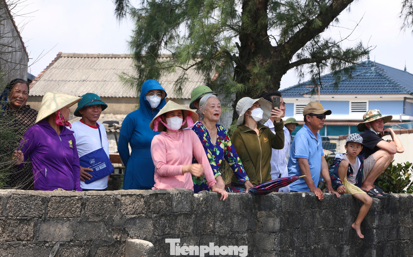 Hàng trăm người dân địa phương cùng du khách có mặt, đứng dọc bãi biển và bờ kè để chiêm ngưỡng lễ hội.