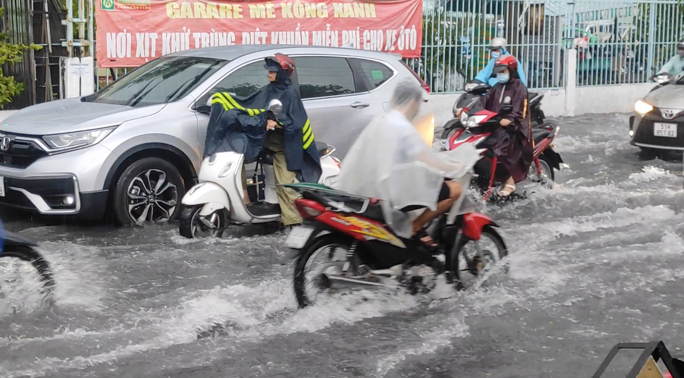 Đường Số 1 và Số 7 đoạn giao An Dương Vương, Q.Bình Tân cũng bị ngập sâu do lượng mưa lớn không thể thoát nước kịp. Rất nhiều phương tiện buộc phải lội qua dòng nước để về nhà, cả đoạn đường qua đây bị kẹt cứng. Một con hẻm nằm trên đường Kinh Dương Vương cũng bị ngập sâu, người dân phải lội bộ dắt xe vào nhà. Đường Phan Anh, Tô Hiệu (Q.Tân Phú), cũng bị ngập sâu do nước kênh dâng cao bất, các chủ phương tiện buộc phải tìm đường khác về nhà. Con kênh dọc đường này dâng cao làm đoạn đường này bị ngập. Đến hơn 18h, mây đen vẫn bao phủ kín cả cửa ngõ phía Tây TP HCM chưa có dấu hiệu dừng mưa. Giao thông kẹt cứng do đường ngập. Theo dự báo của đài khí tượng thuỷ văn Nam Bộ mây giông trên khu vực Campuchia cũng đang phát triển mạnh, vùng phản hồi này ít di chuyển và đang gây ra mưa giông cho TP HCM và một số tỉnh miền tây. Trình duyệt của bạn không hỗ trợ hiển thị video.