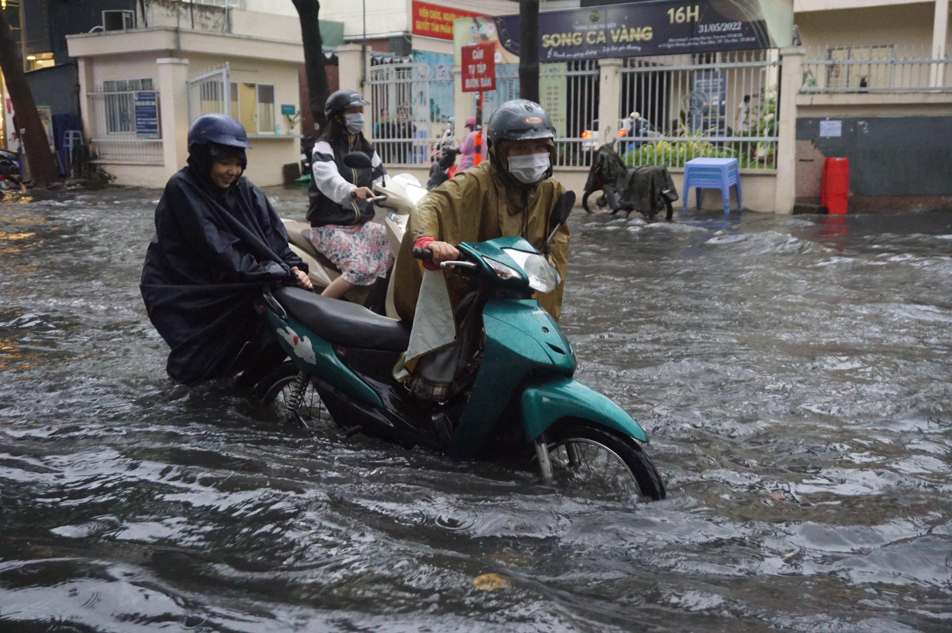 Người dân vất vả đẩy xe máy qua tuyến đường ngập ở Thảo Điền.
