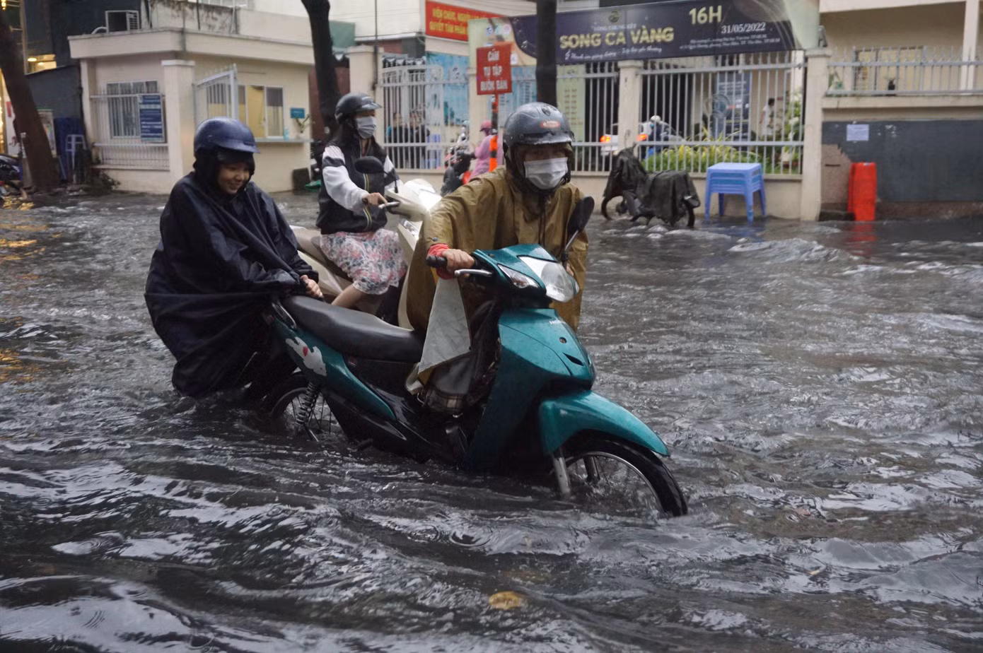 Người dân vất vả đẩy xe máy qua tuyến đường ngập ở Thảo Điền. Người dân vất vả đẩy xe máy qua tuyến đường ngập ở Thảo Điền.