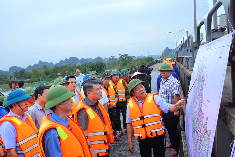 Trưởng Ban Tổ chức Trung ương Lê Minh Hưng đứng giữa hàng đầu (không đội mũ), nghe báo cáo về việc vận hành tràn Lạc Khoái, sông Hoàng Long. Ảnh: N.B.