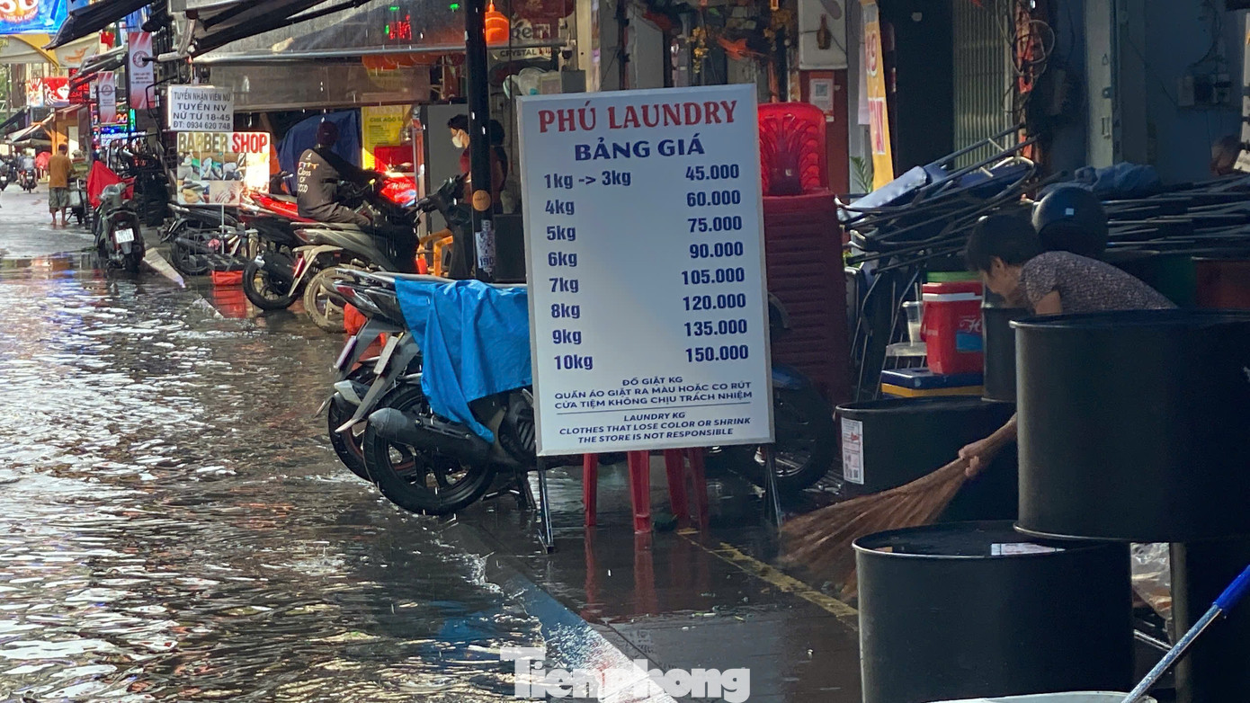 Nhân viên các hàng quán hai bên đường tất bật dọn dẹp, thu gom rác, khơi thông miệng cống để nước rút nhanh hơn. Nhân viên các hàng quán hai bên đường tất bật dọn dẹp, thu gom rác, khơi thông miệng cống để nước rút nhanh hơn.