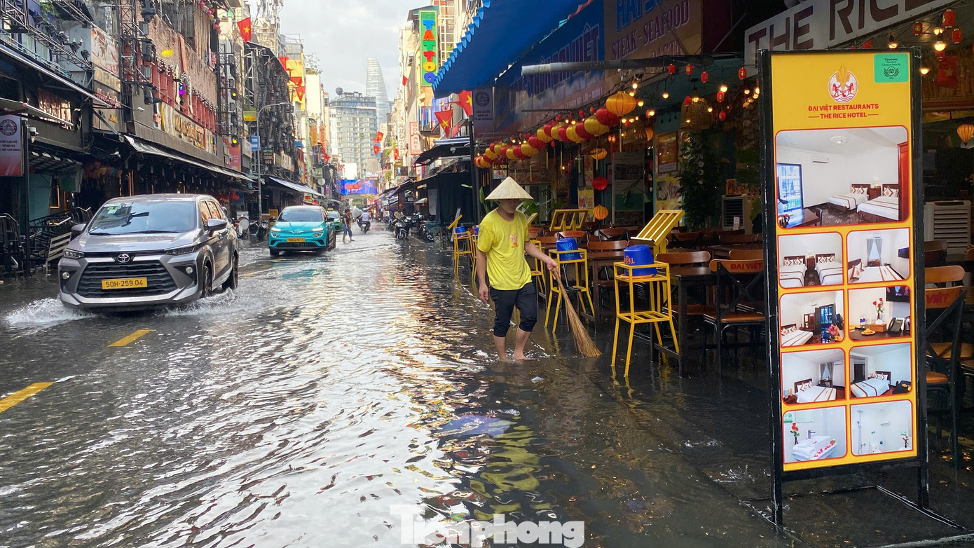 Nhân viên các hàng quán hai bên đường tất bật dọn dẹp, thu gom rác, khơi thông miệng cống để nước rút nhanh hơn. Nhân viên các hàng quán hai bên đường tất bật dọn dẹp, thu gom rác, khơi thông miệng cống để nước rút nhanh hơn.